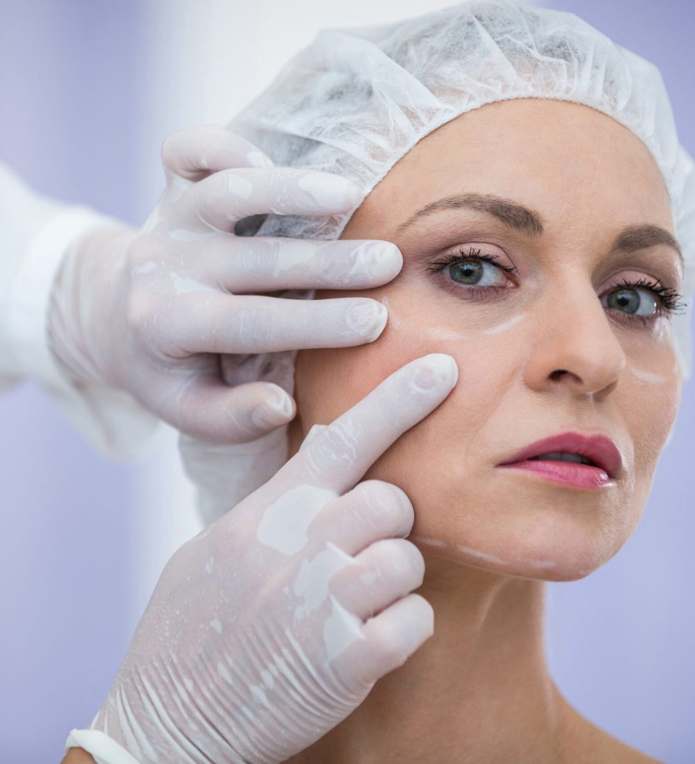 Close-up of doctor examining female patients face for cosmetic treatment