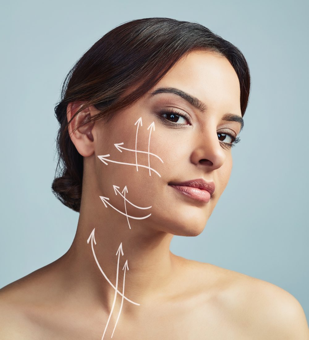 Portrait, woman and skincare with arrow for plastic surgery in studio, facial treatment and beauty filler of change. Girl, lines and procedure of face lift, medical transformation and gray background.